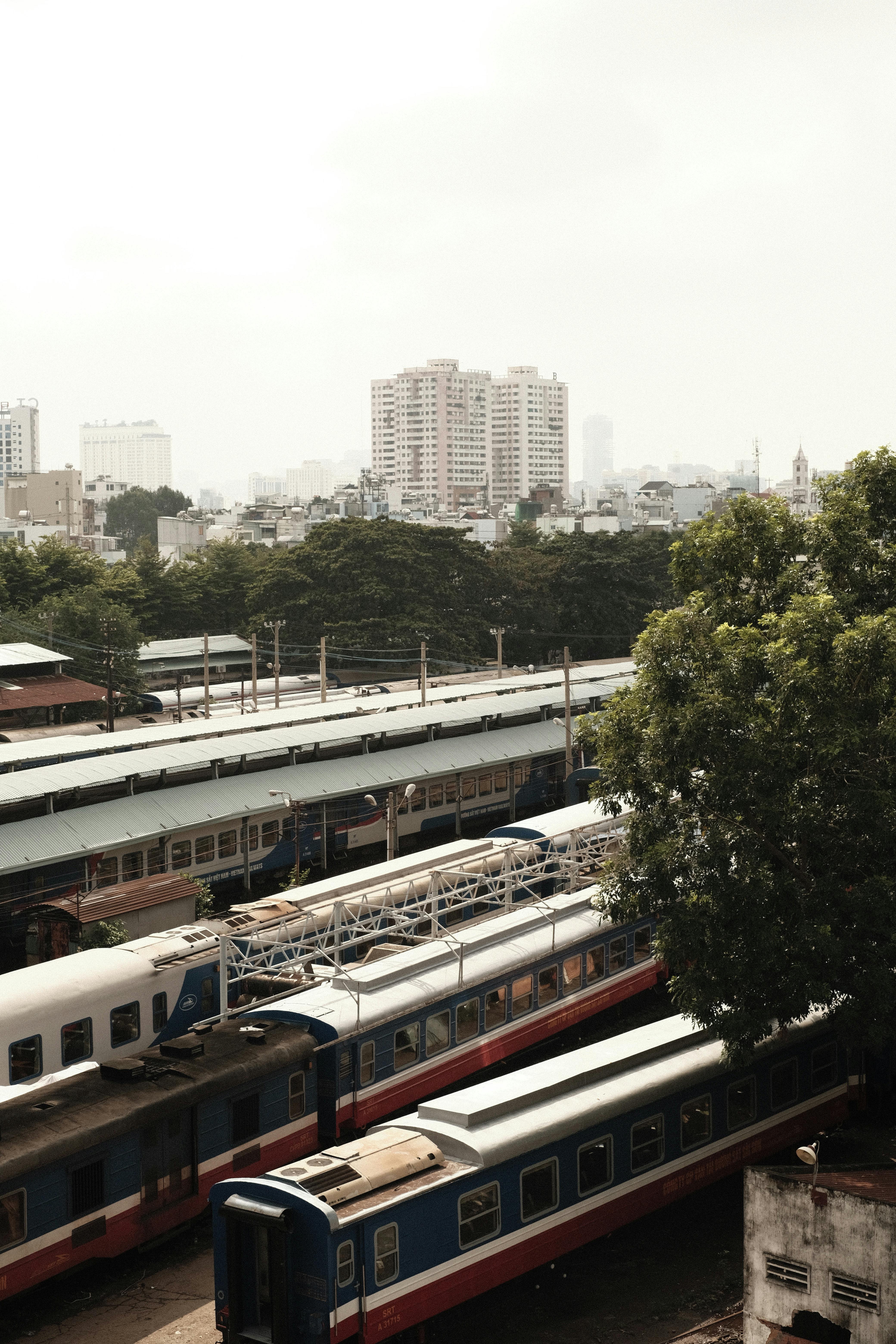 Aerial view of a city with railway tracks and high-rise buildings, showcasing urban life.