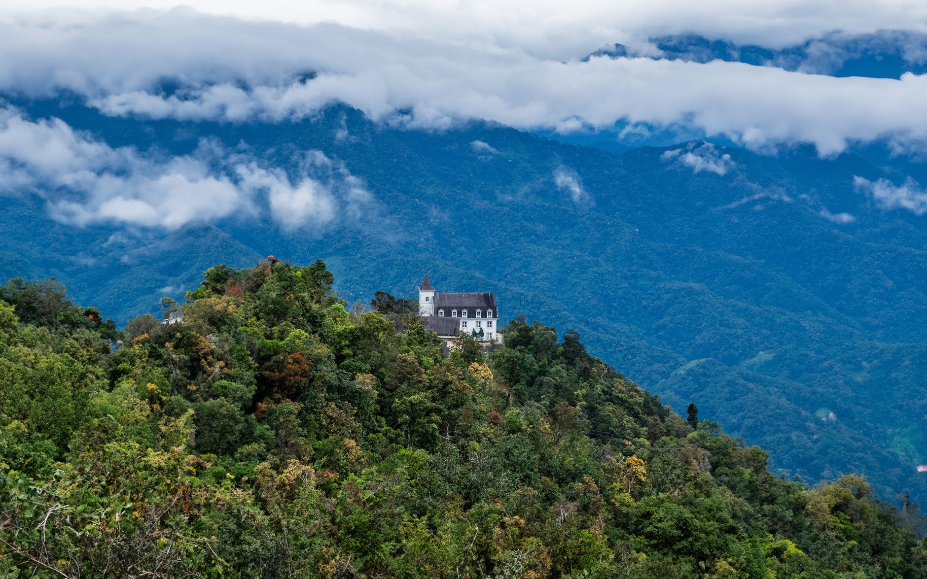 Stunning view of lush mountain landscape with a solitary building in Da Nang, Vietnam.