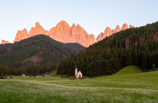 Scenic sunset view of Val di Funes with Santa Maddalena church and Dolomites mountains in Trentino-South Tyrol, Italy.