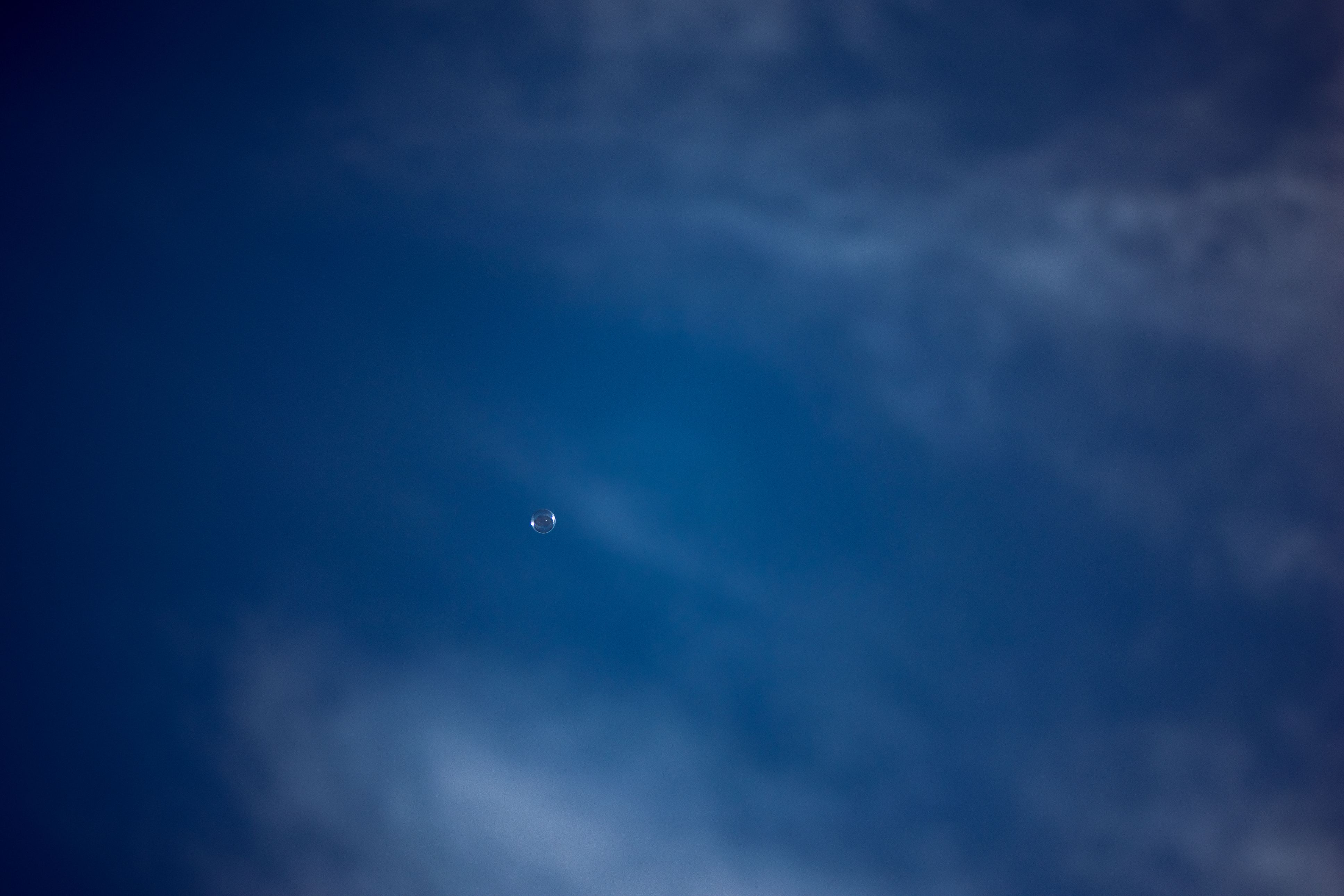 A small plane flying through a blue sky · Free Stock Photo