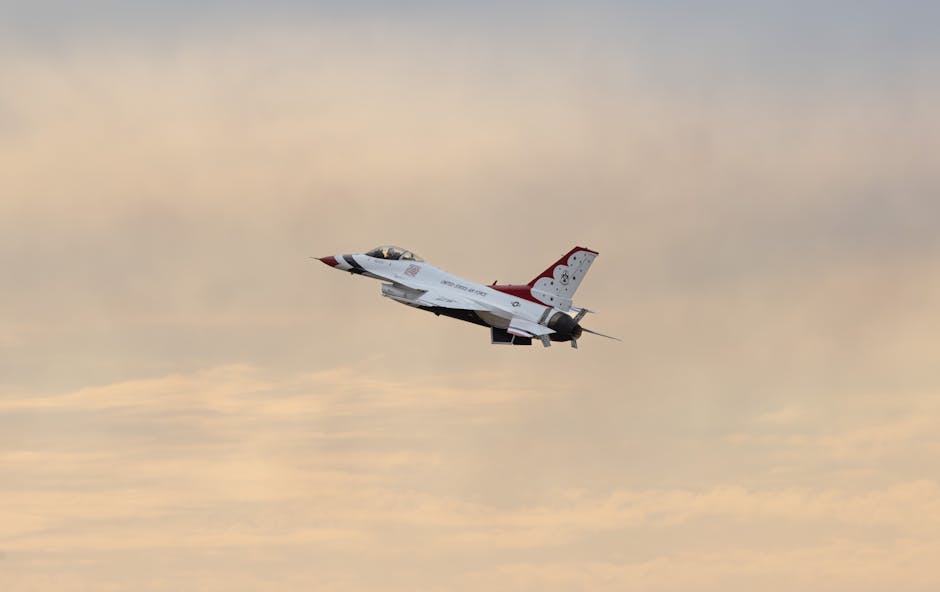 A military fighter jet soaring through the sky with a colorful sunset backdrop, showcasing speed and precision.