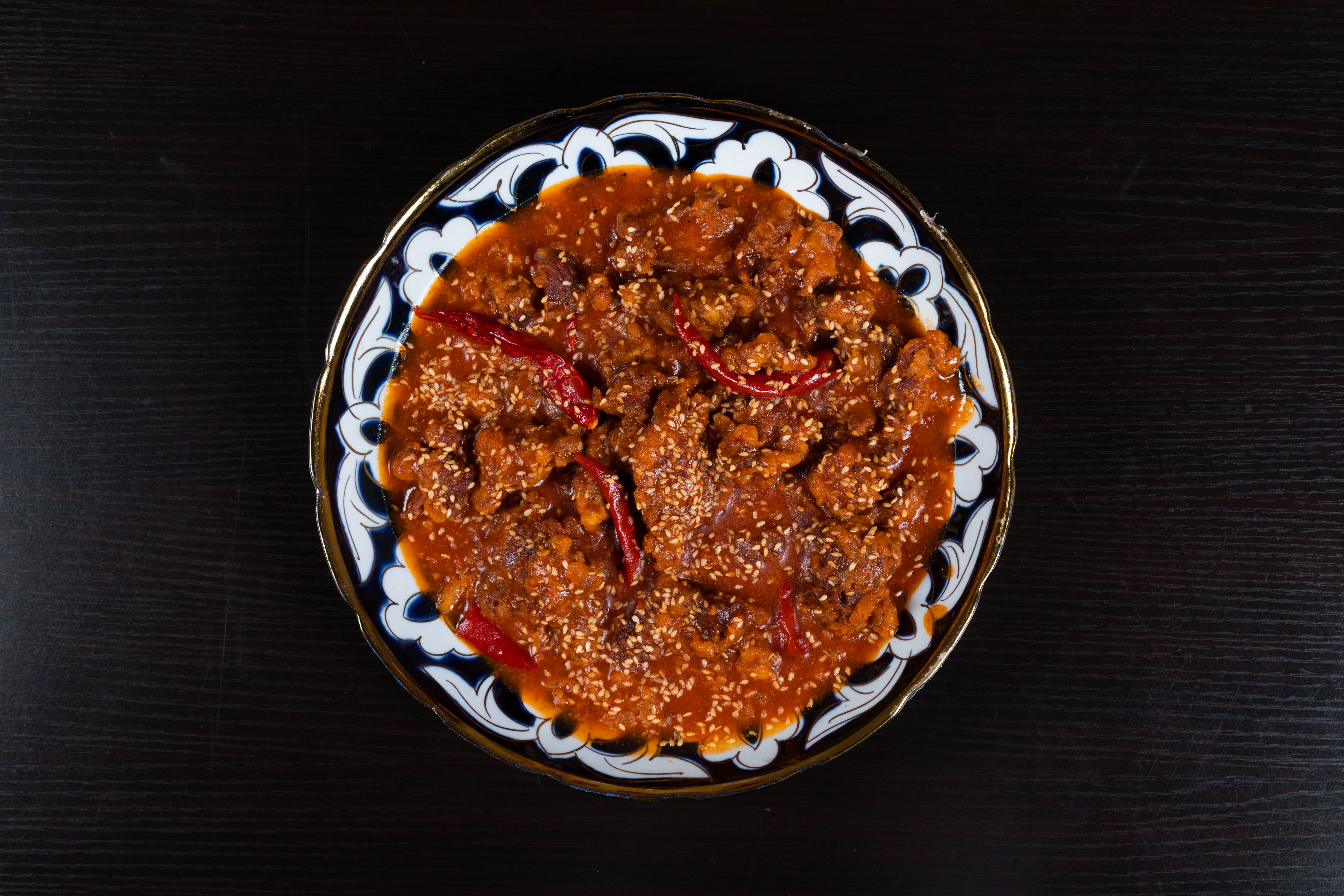 Top-down view of spicy Korean beef with sesame seeds served on a decorative plate, perfect for Asian cuisine lovers.