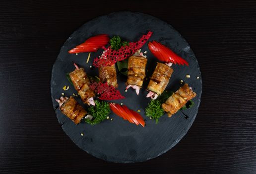 Delicious gourmet seafood wraps with vibrant garnishes on a slate platter, perfect for elegant dining.