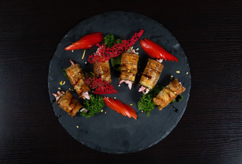 Rolled wraps garnished on a dark slate platter — photo by Collab Media on Pexels