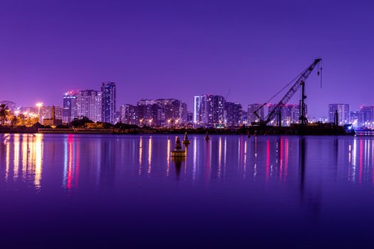 Stunning view of the Dubai skyline at twilight, reflecting on the calm water, featuring modern architecture.