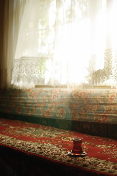Free Warm sunlight streams through lace curtains onto a vintage tea setting. Stock Photo