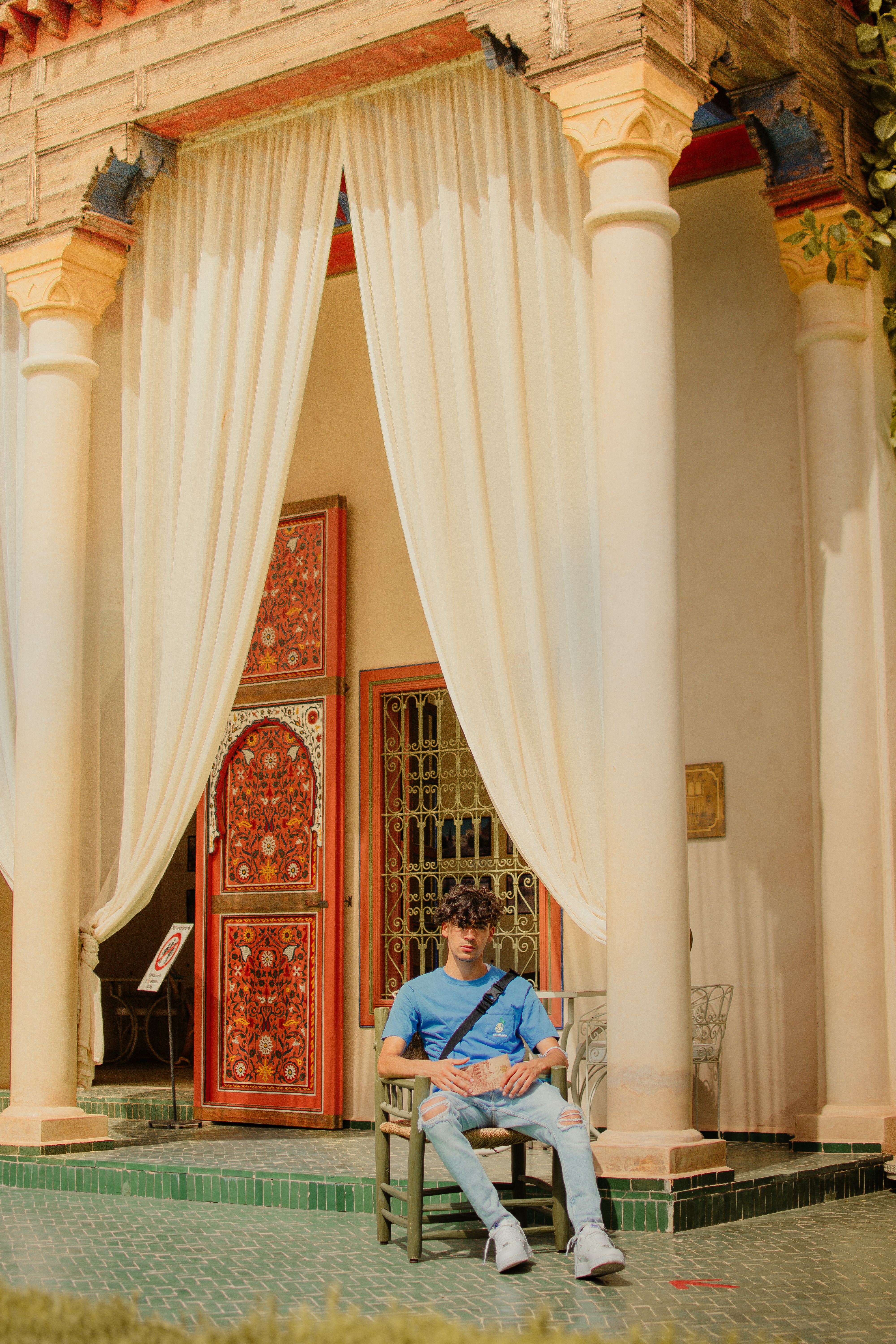 A man sitting on a bench outside of a building · Free Stock Photo