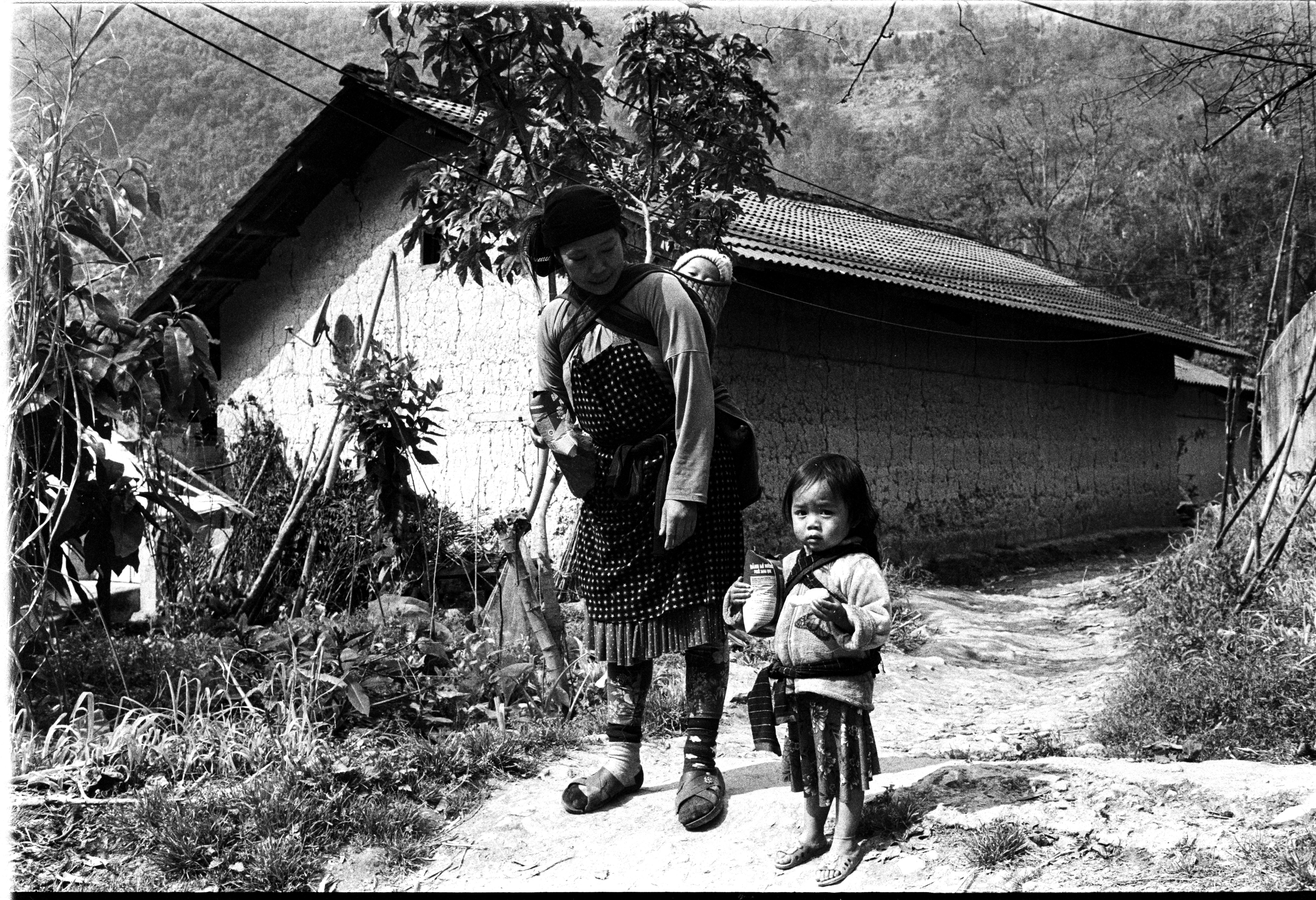 Vintage portrait of a woman and child in Hà Giang, Vietnam, showcasing traditional attire.