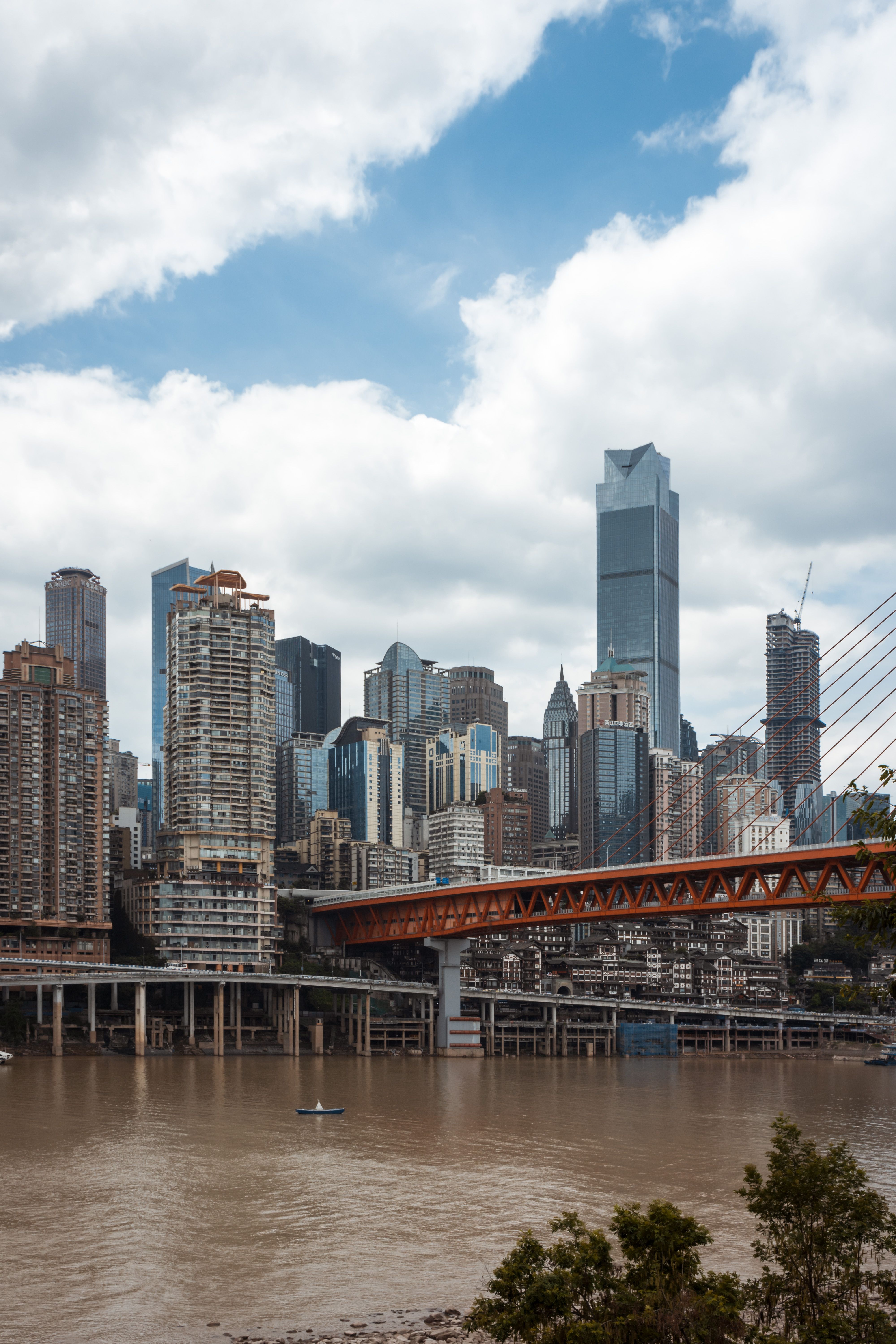 A city skyline with a bridge over a river · Free Stock Photo