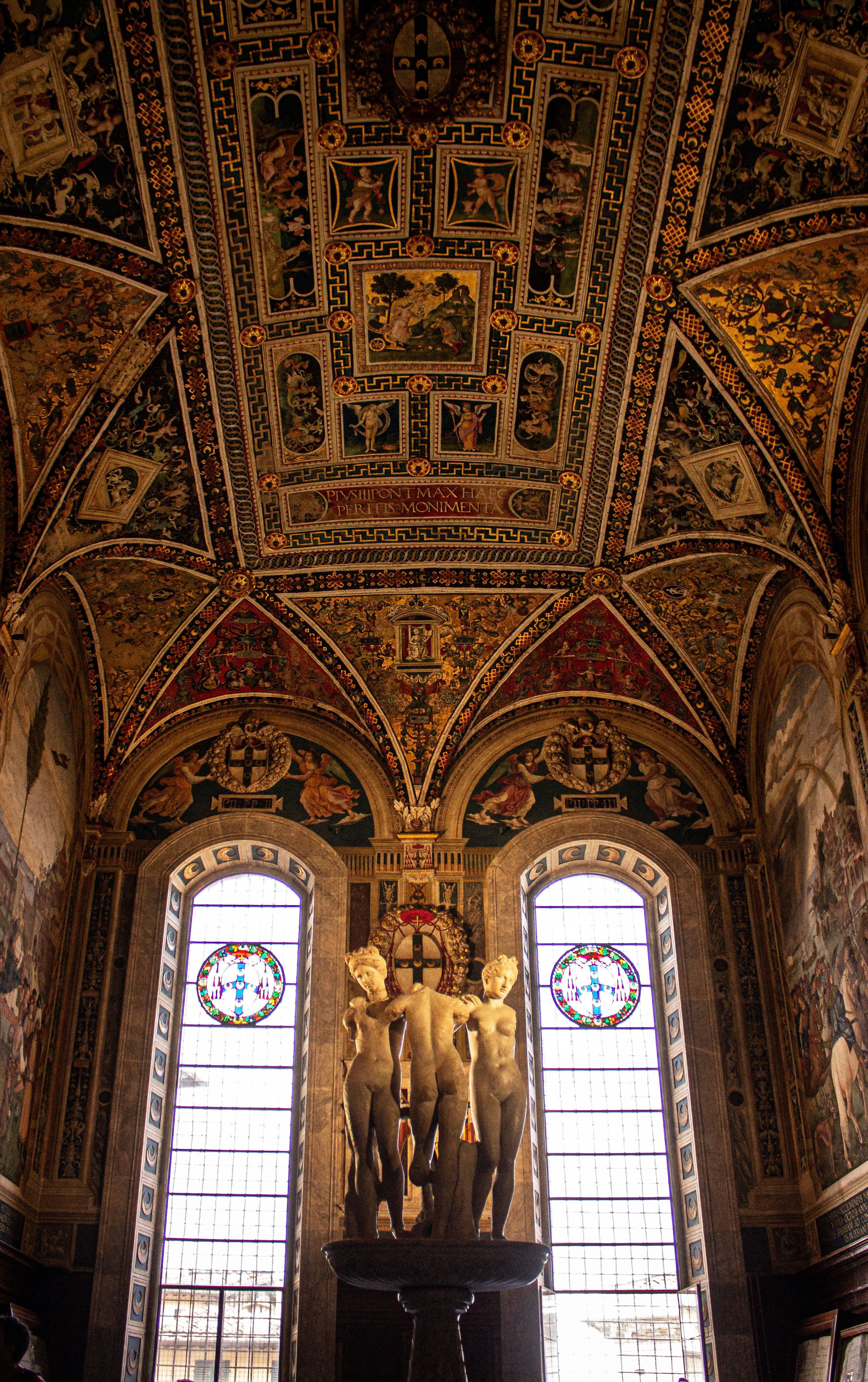 Detailed view of a richly decorated cathedral ceiling with classical sculptures below.