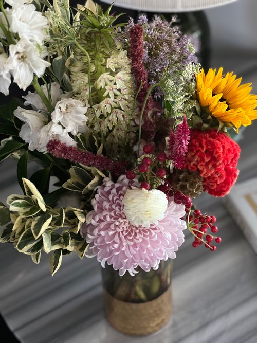 Free Colorful floral arrangement featuring sunflowers, chrysanthemums, and more in a vase. Stock Photo