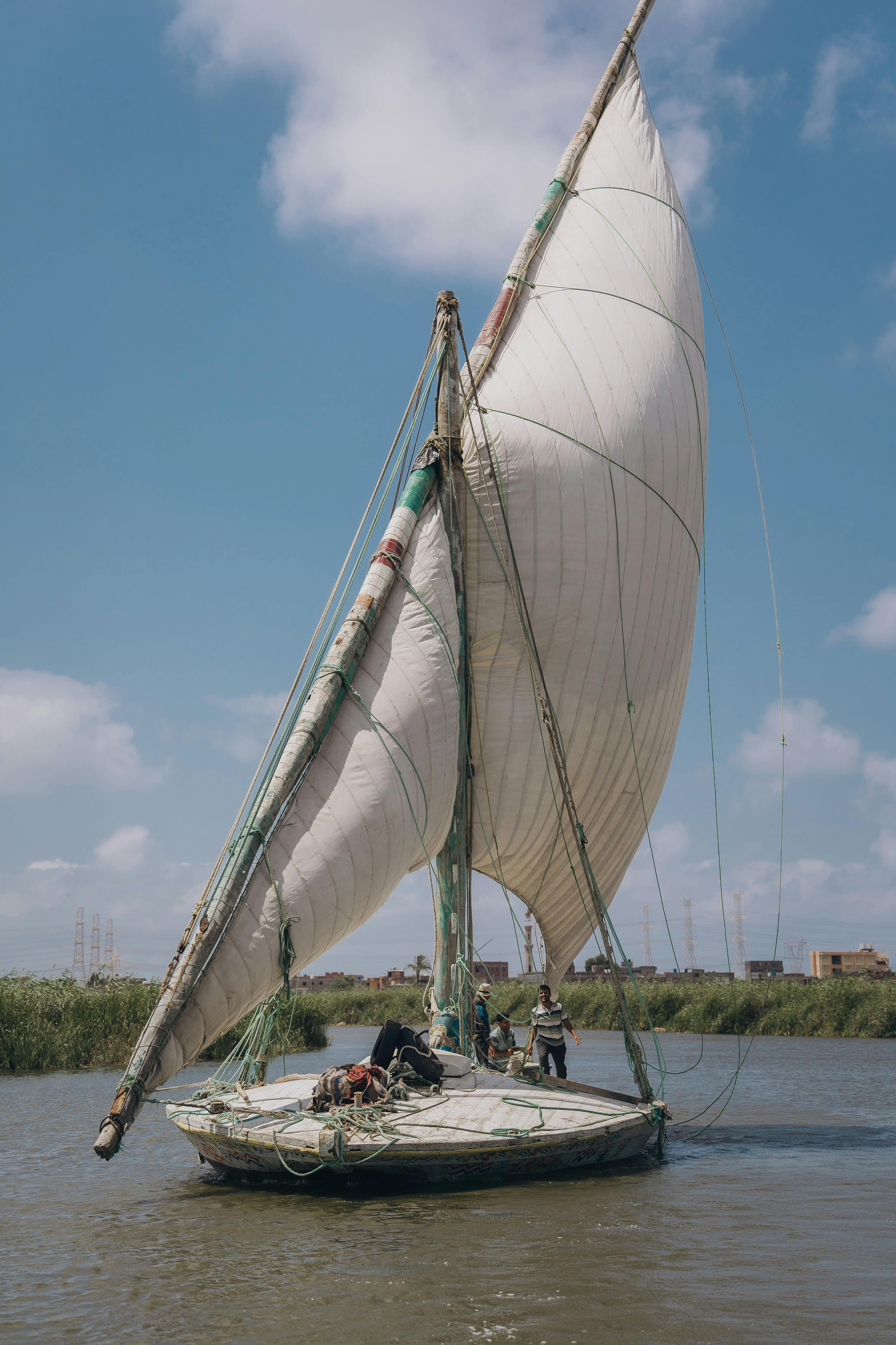 Sailing on the Nile River with traditional Egyptian felucca, capturing serene outdoor scenery.