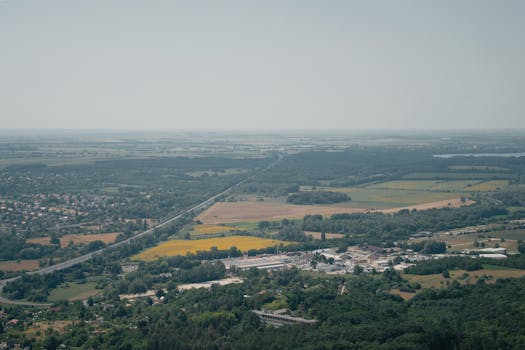 Expansive aerial view of fields, roads, and a small town in Hungary's countryside.