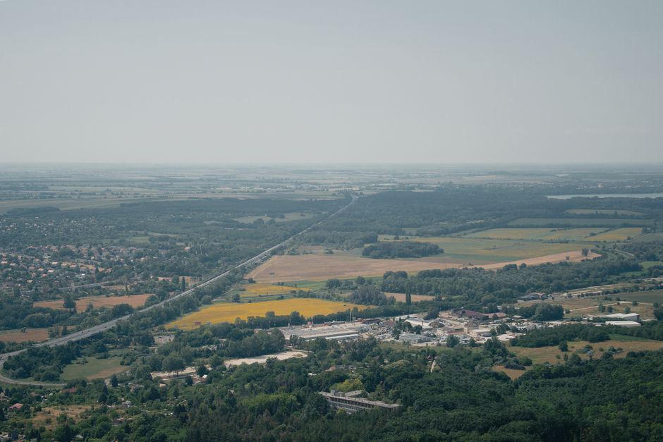Expansive aerial view of fields, roads, and a small town in Hungary's countryside.