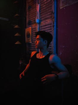 Dramatic portrait of a man in dark and colorful lighting creating a vivid contrast.