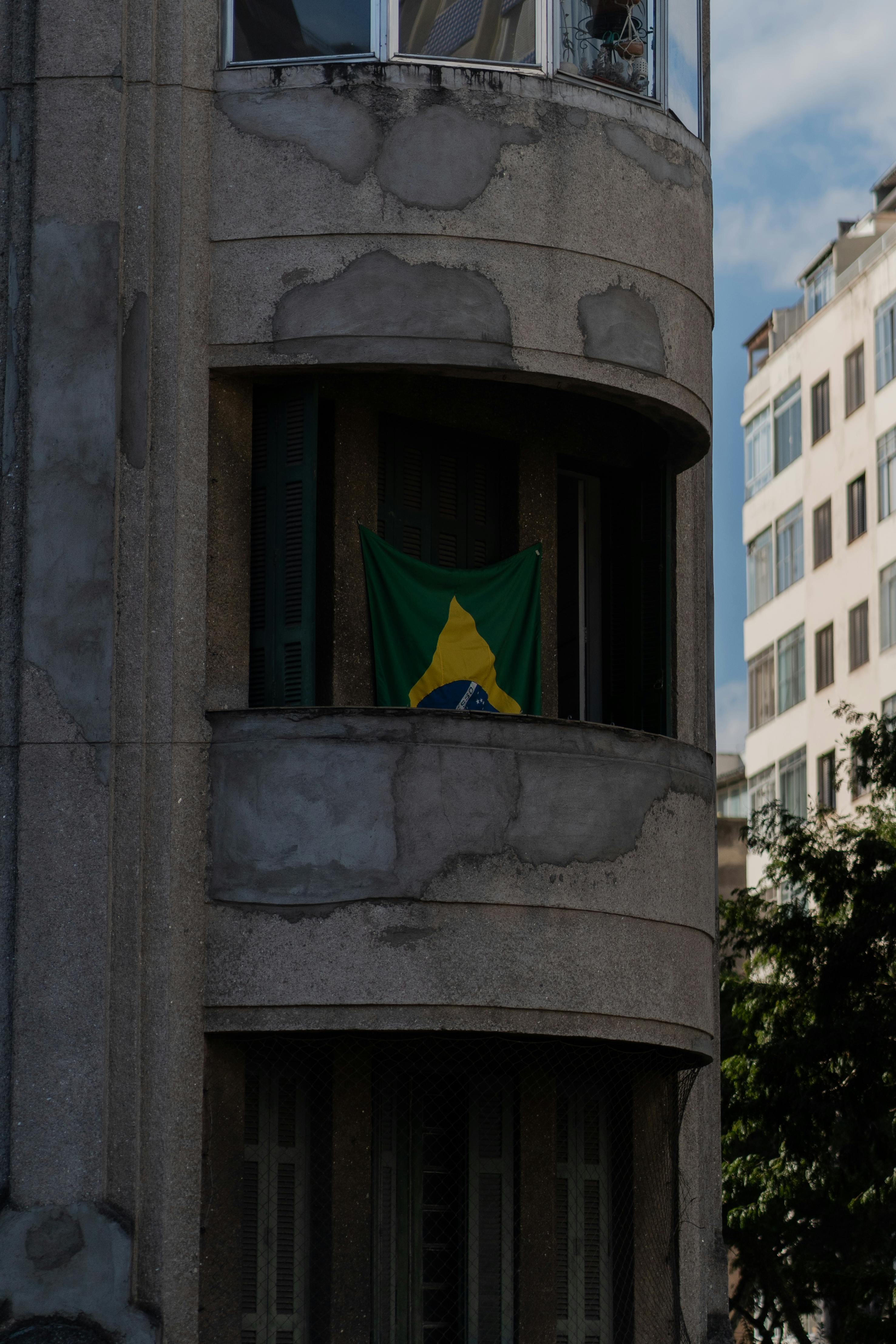 a brazilian flag is flying in front of a building