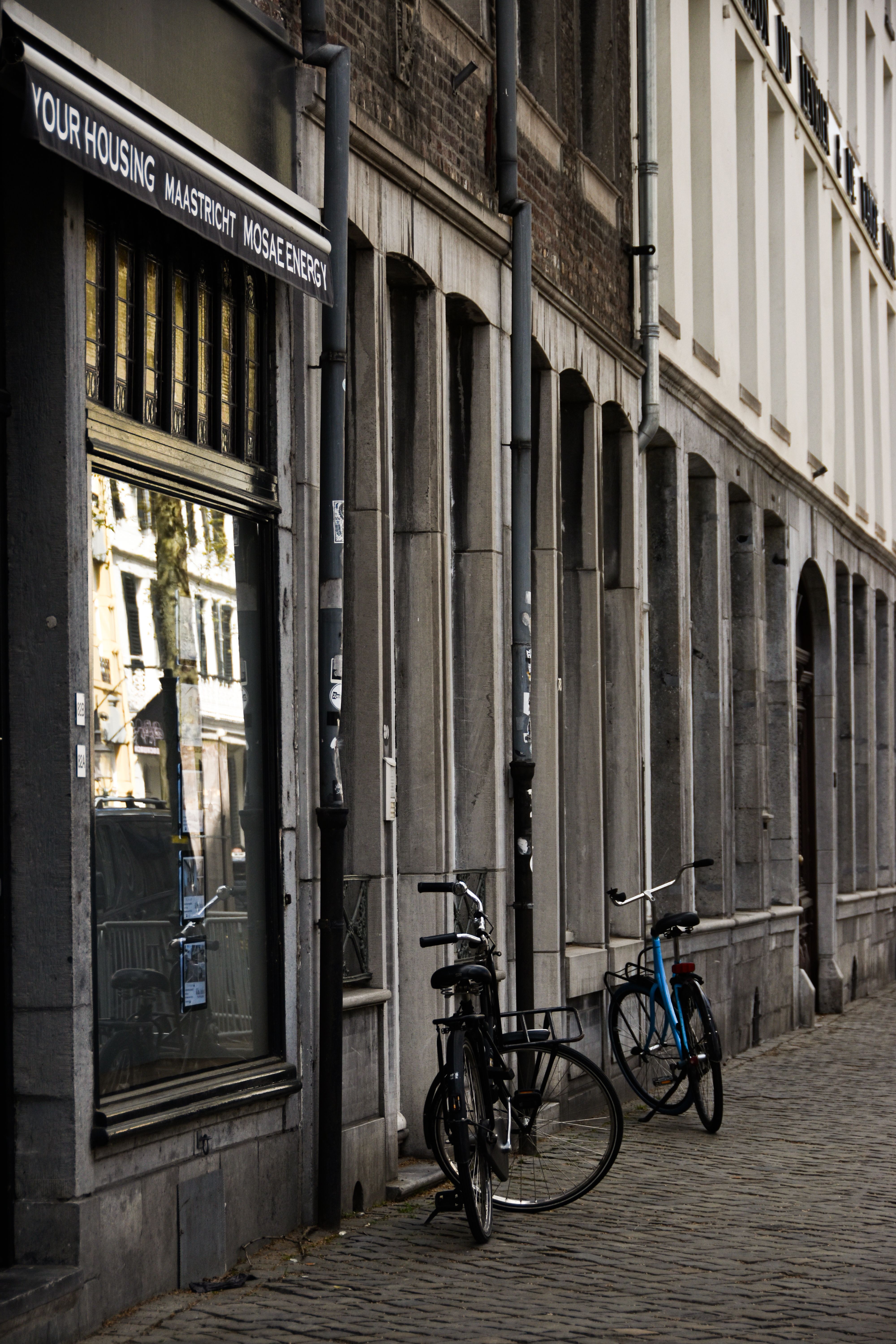 Charming Maastricht street with historical architecture and bicycles parked along the cobblestone road.