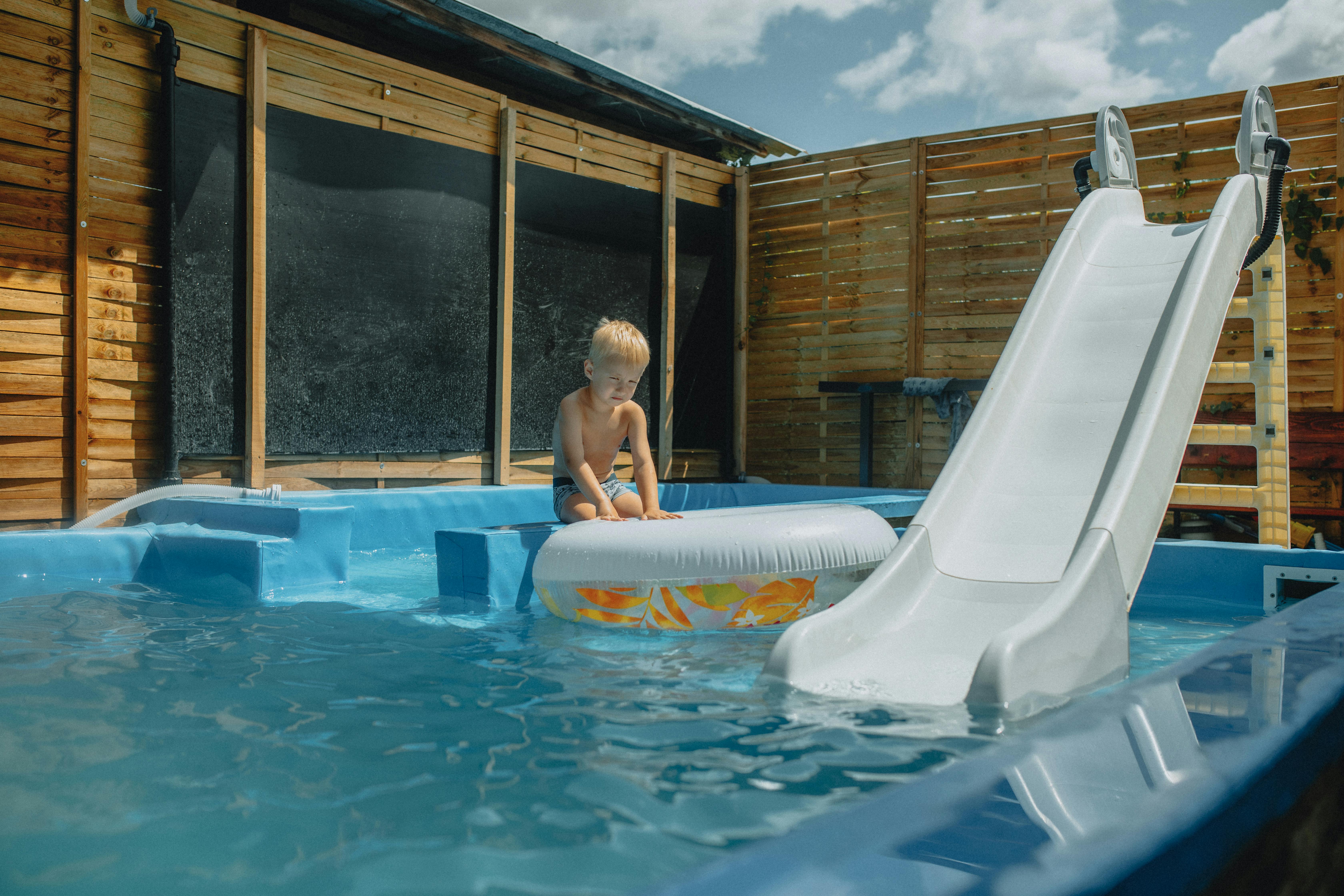 a child playing in an inflatable pool with a slide