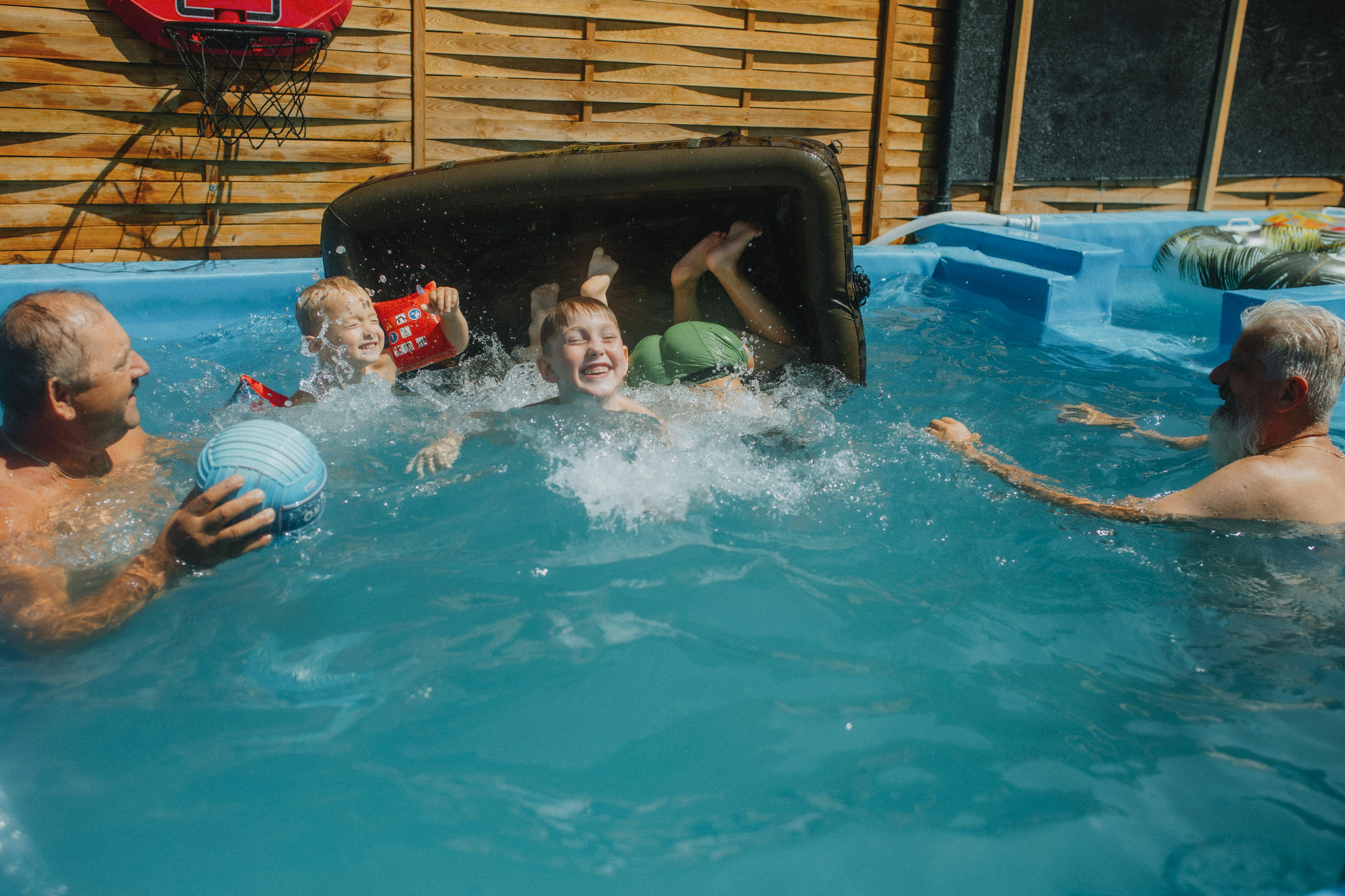 a group of people playing in a pool with a toy