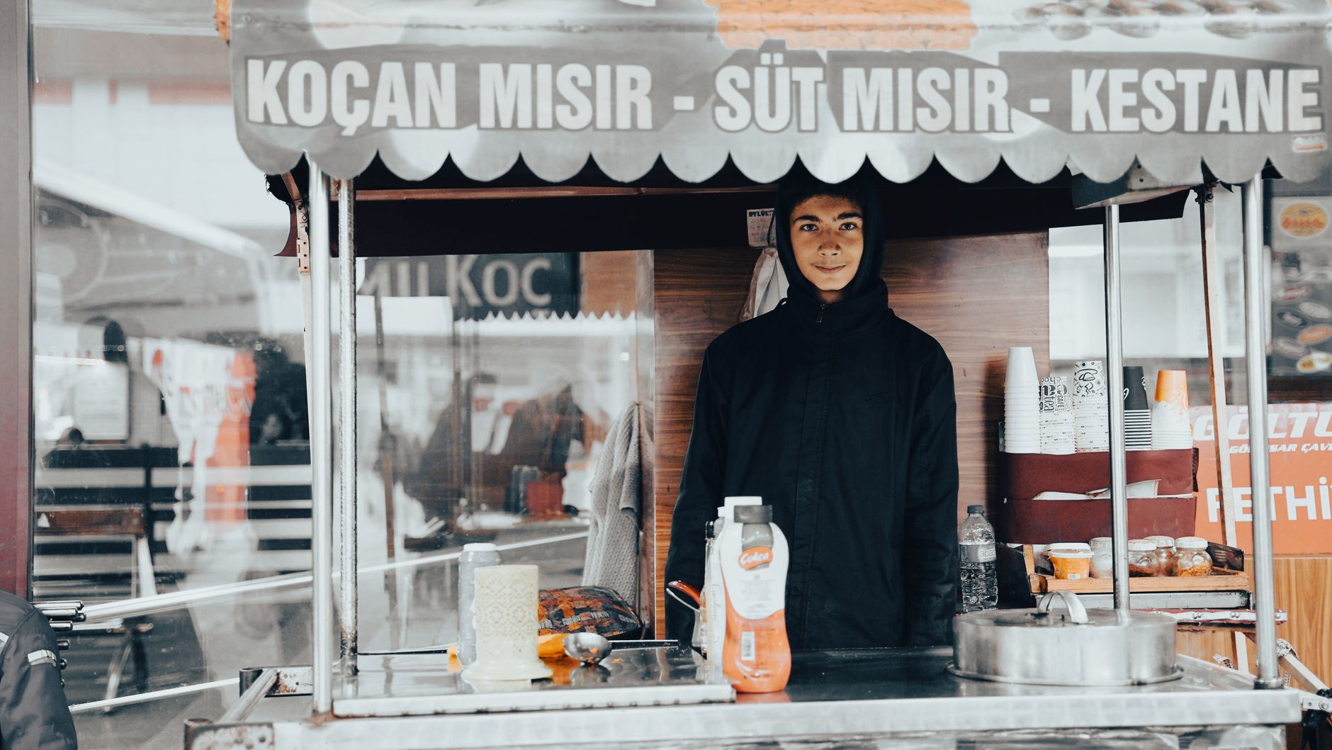 A young street vendor sells corn at a market stall in Isparta, Turkey.