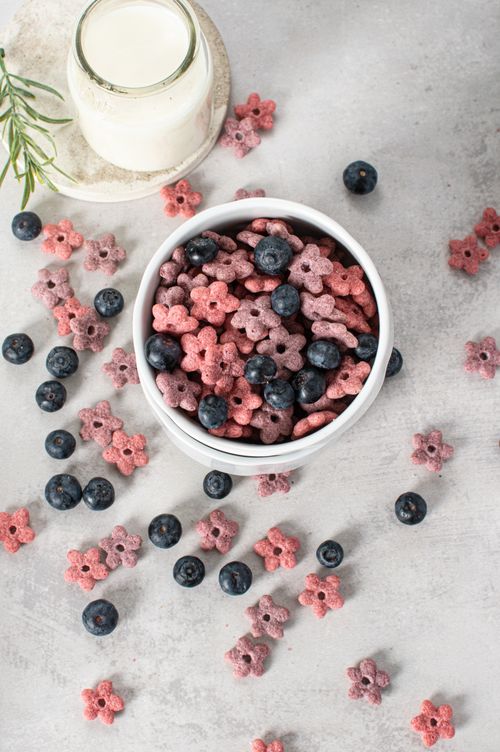 Free A bowl of berry cereal with fresh blueberries and milk on a light surface. Stock Photo