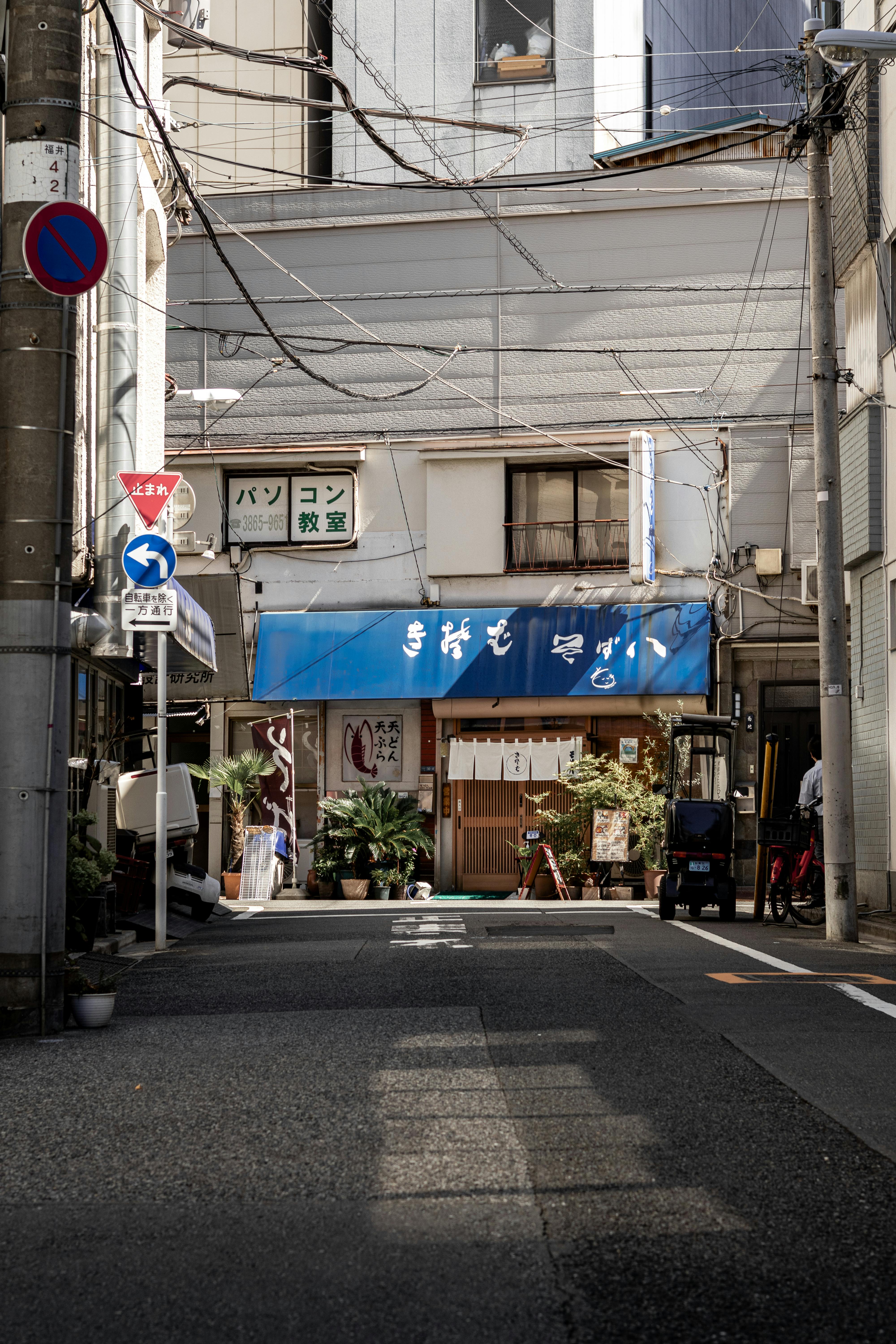 a street with a blue building and a sign