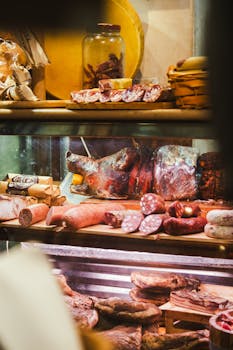 A detailed view of various meats displayed in a traditional Roman deli, showcasing salami and cured meats.