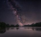 Captivating view of the Milky Way reflecting over a serene river in Gola, Croatia.