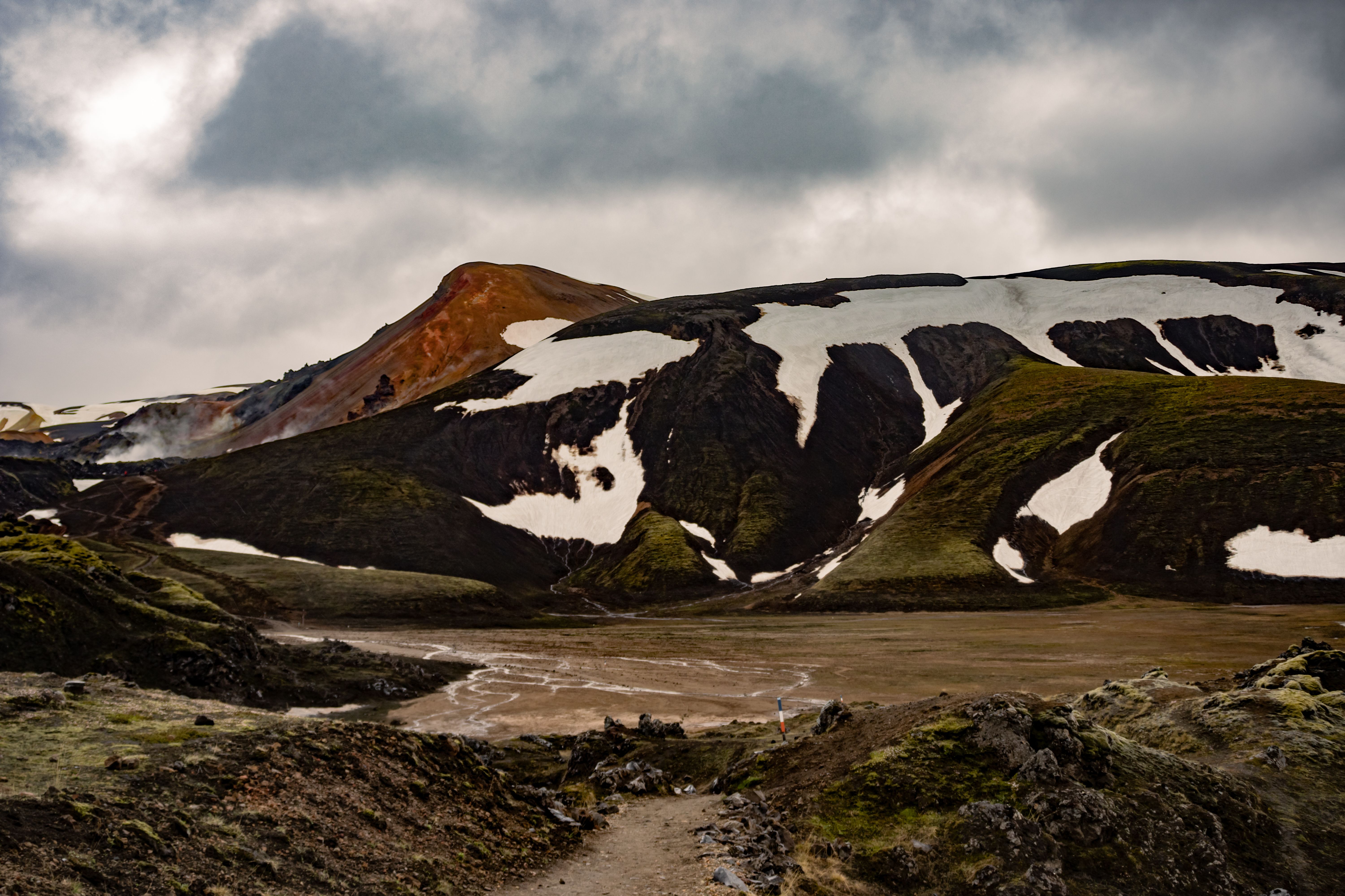 A stunning view of Iceland's rugged landscape featuring snow-capped mountains and vibrant geological formations. A stunning view of Iceland's rugged landscape featuring snow-capped mountains and vibrant geological formations.