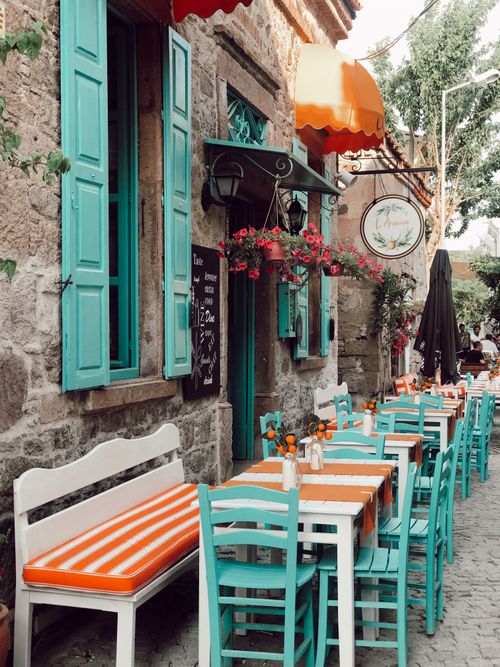 Free Charming street cafe with vibrant furniture and traditional stone architecture in Balıkesir, Turkey. Stock Photo