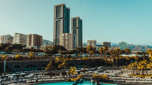 Free A scenic urban skyline with towering buildings and a resort pool in foreground. Stock Photo