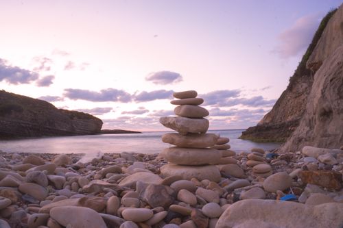 Free Serene pebble stack on a rocky İstanbul beach during a vibrant sunset. Perfect for travel and zen themes. Stock Photo