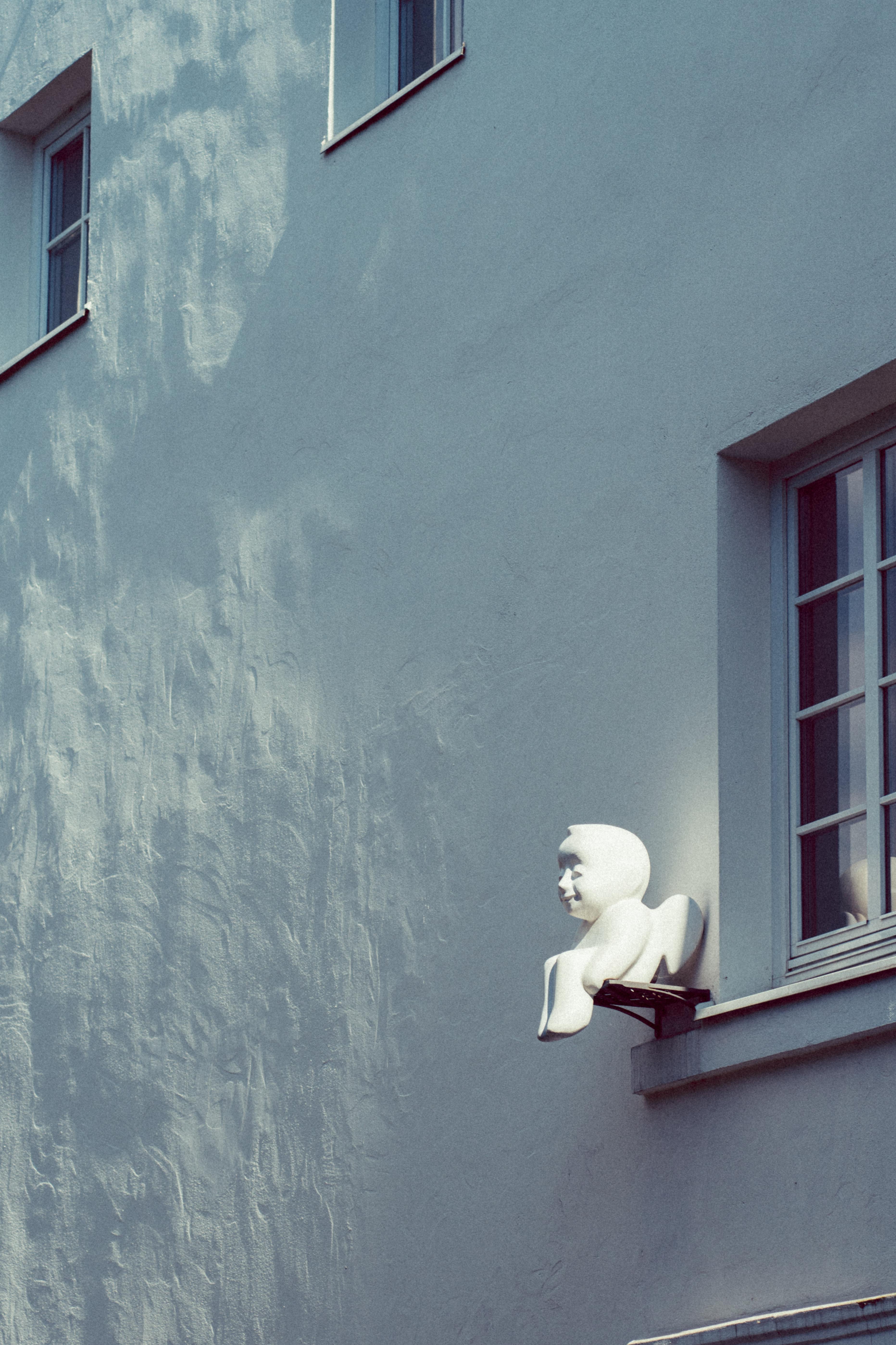 A modern sculpture adorns a building facade in Vilnius, capturing a minimalist urban aesthetic.