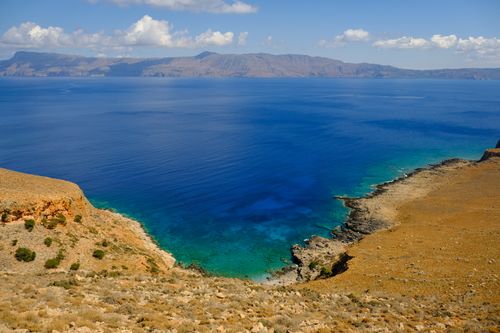 Free A breathtaking view of turquoise waters and rocky cliffs under a sunny sky. Stock Photo