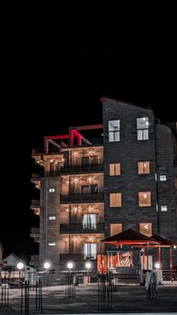 A stylish modern building beautifully illuminated against the night sky, showcasing architectural elegance.