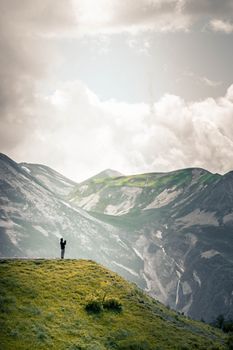 在格鲁吉亚山脉的壮丽景色中，孤独的人拥抱大自然