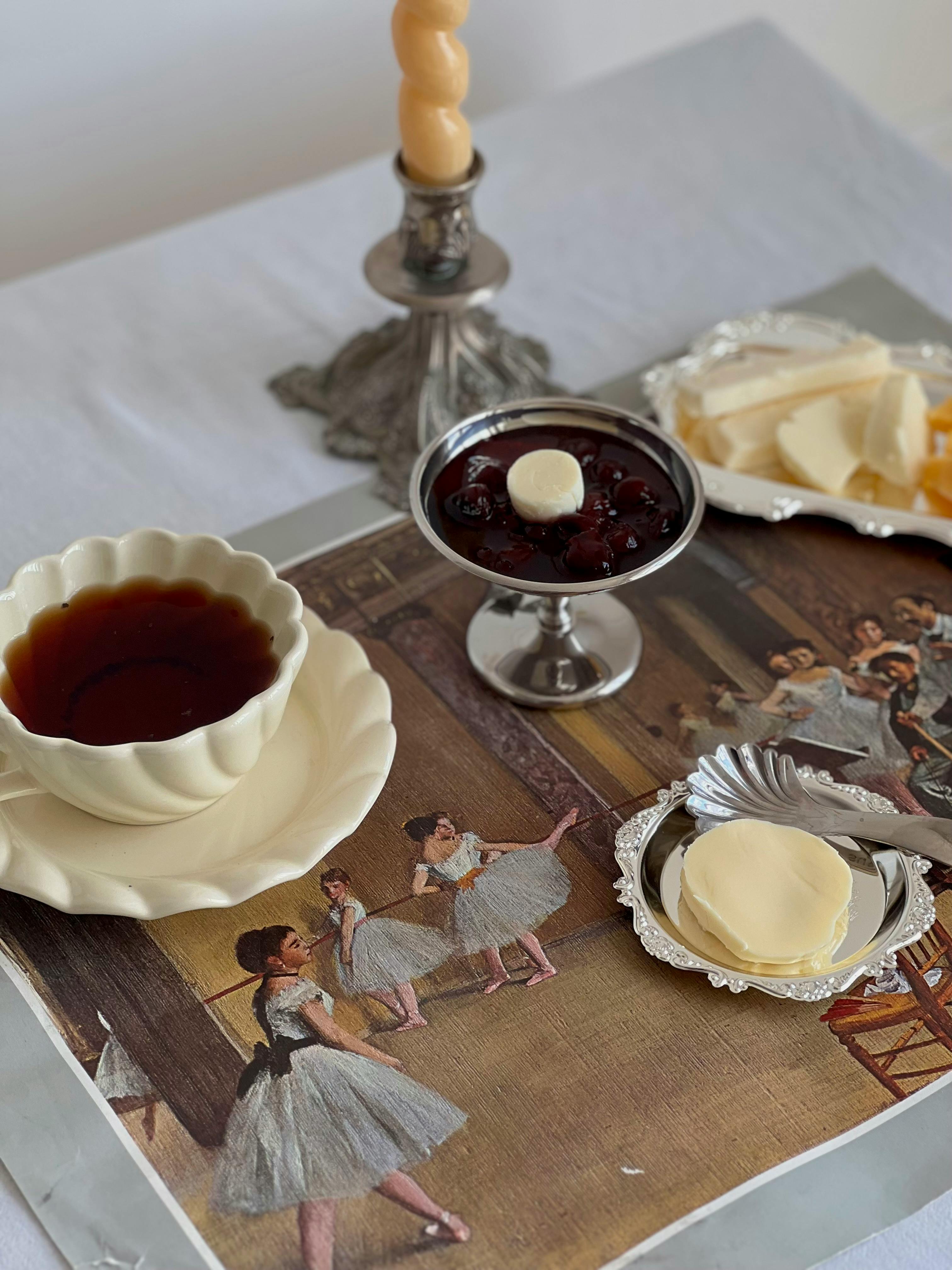 Charming afternoon tea setup with vintage-style dishes and ballerina artwork.