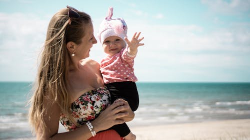Free Woman Carrying Baby On Shore  Stock Photo