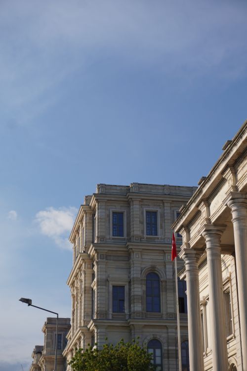 Free A classic historic building in İstanbul with a Turkish flag and clear blue sky. Stock Photo