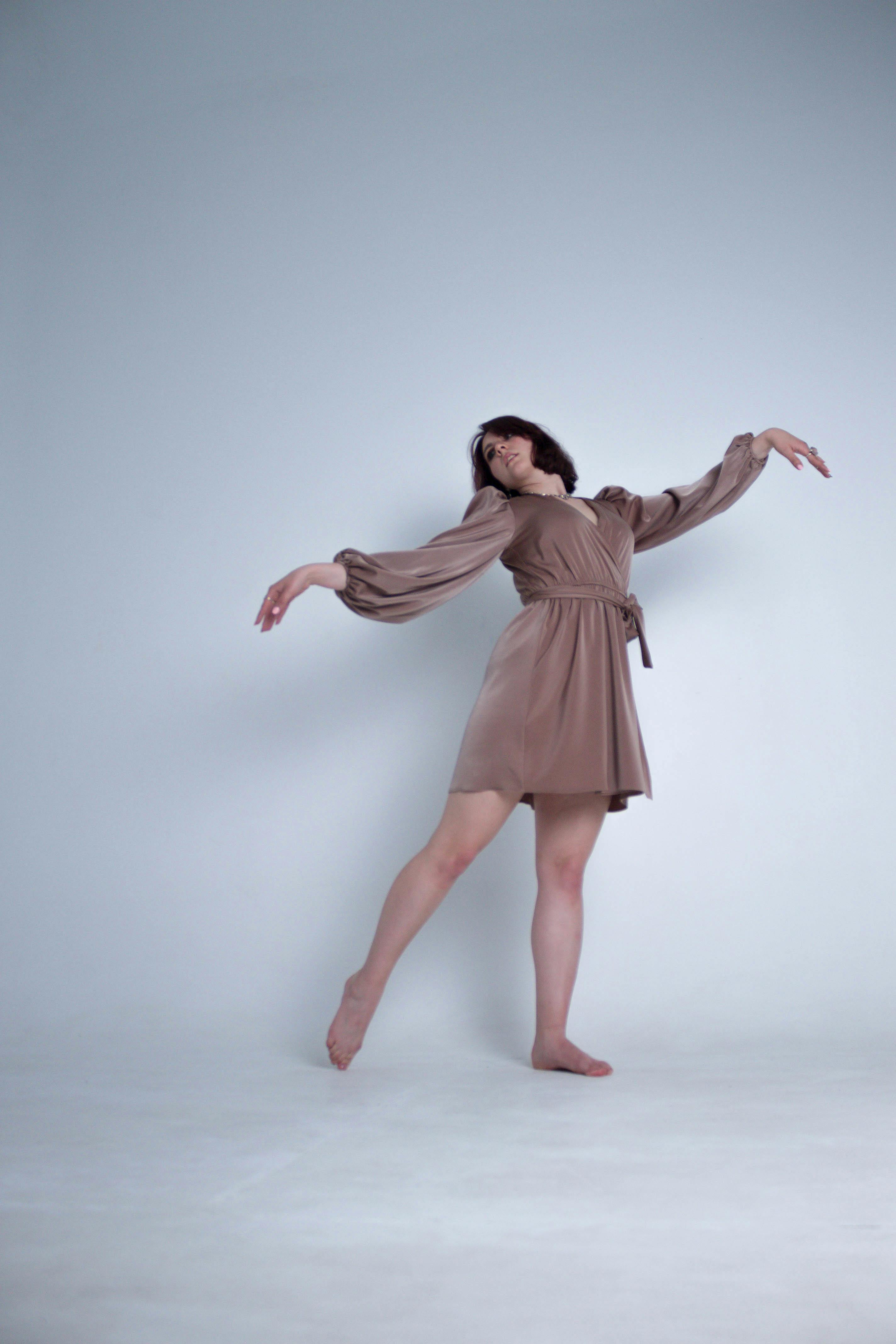 a woman in a brown dress is dancing