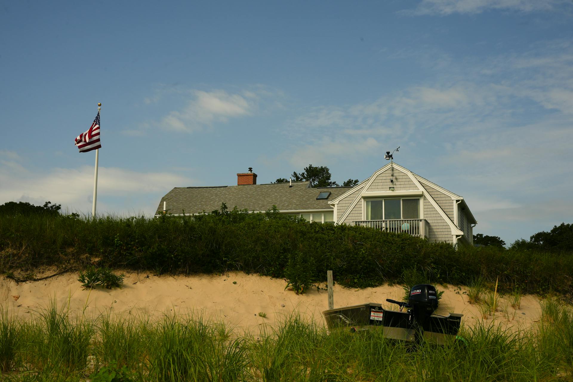 A house on the beach with an american flag flying