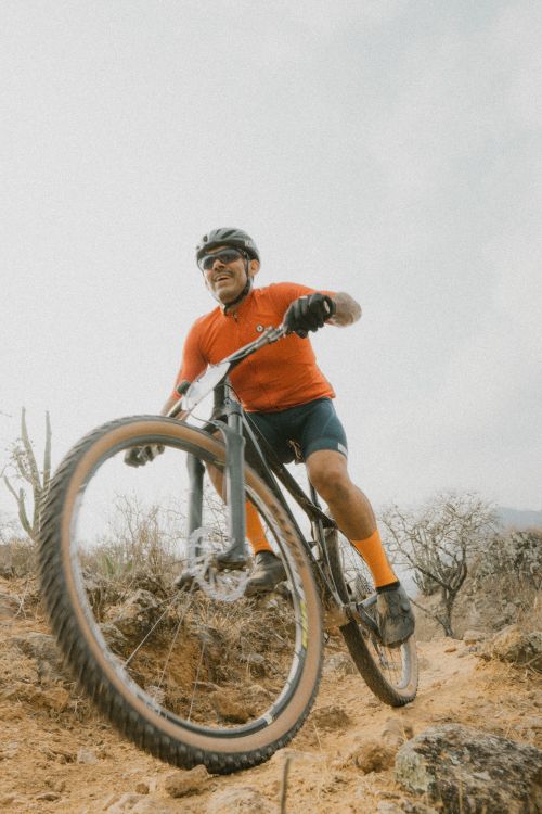 Free A cyclist rides a mountain bike energetically on a rugged outdoor trail, capturing the thrill of adventure. Stock Photo