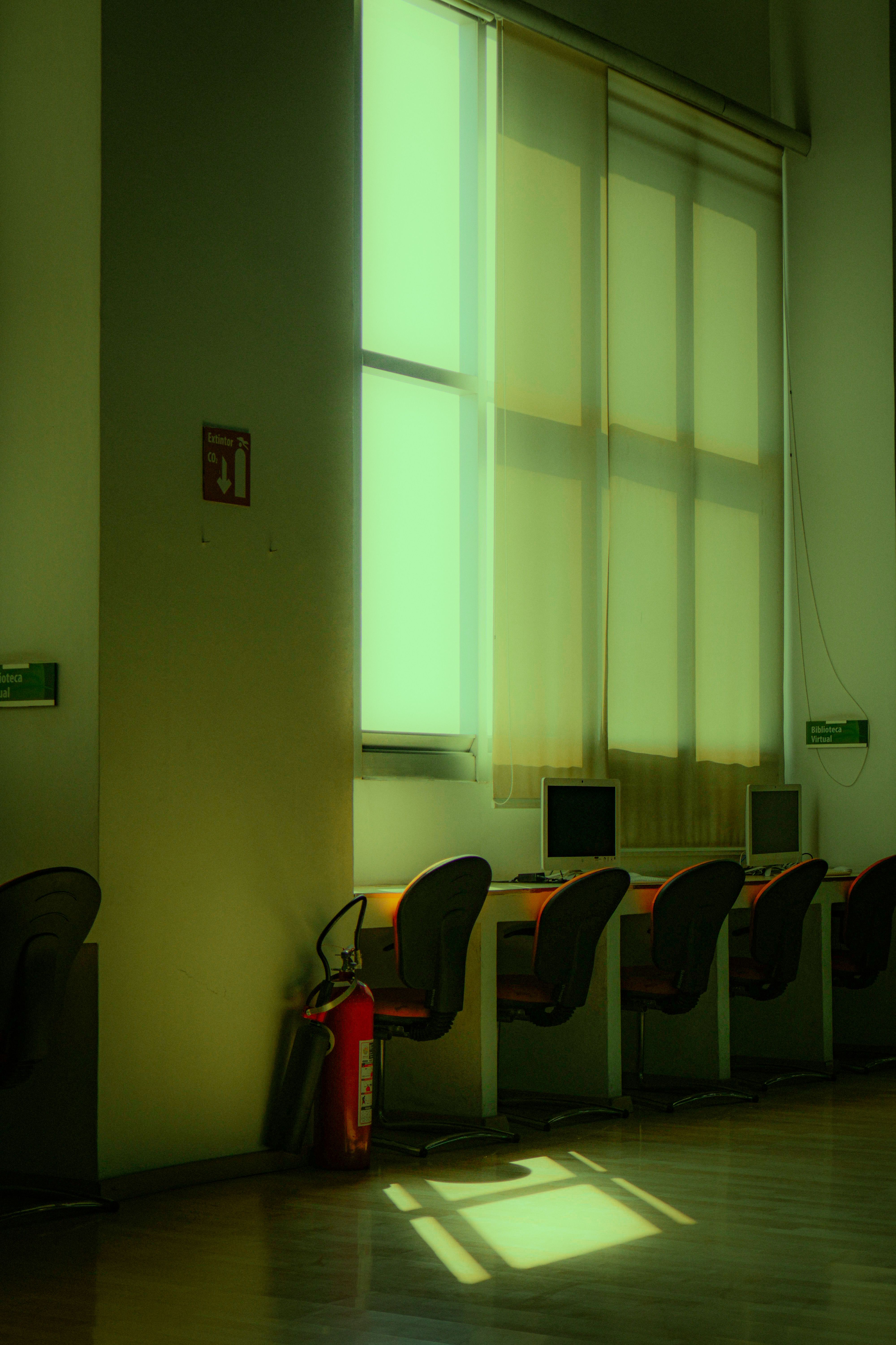 Bright and minimalist office space with computer desks and large windows.