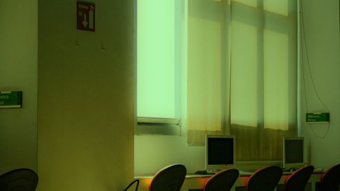 Bright and minimalist office space with computer desks and large windows.