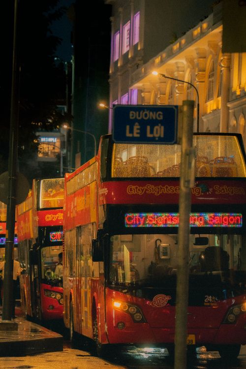 Free Double-decker buses on Le Loi Street, bustling with night energy in Ho Chi Minh City. Stock Photo