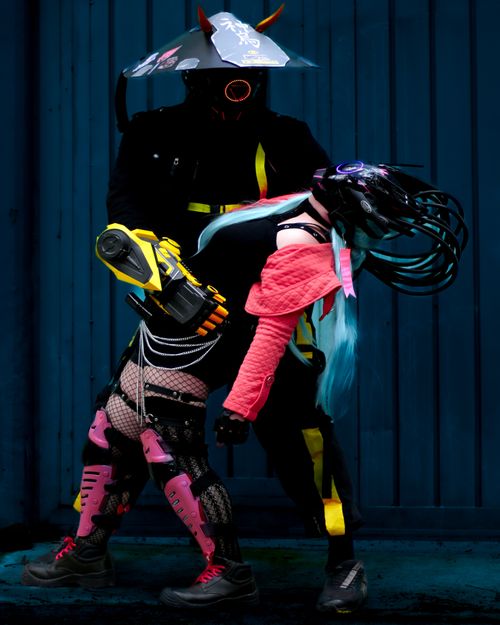 Free Dynamic cyberpunk costumed dancers in vibrant street fashion pose artistically. Stock Photo