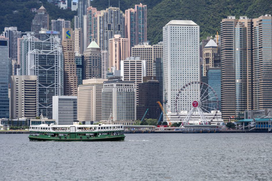 Stunning view of Hong Kong skyline featuring Victoria Harbour and the famous Star Ferry in daytime.