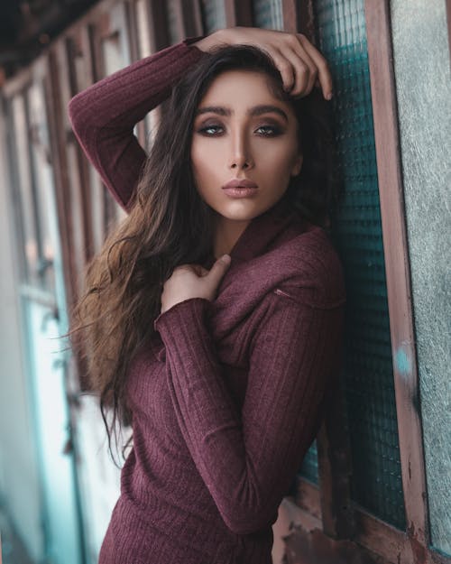 Woman In Brown Top Leaning On Wall