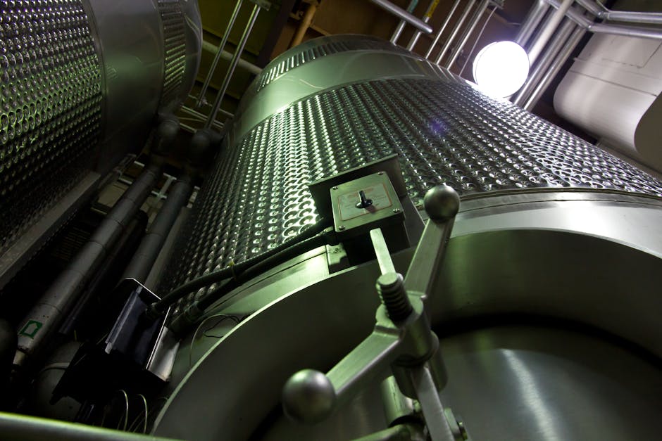 Velké nerezové nádrže uvnitř průmyslového závodu