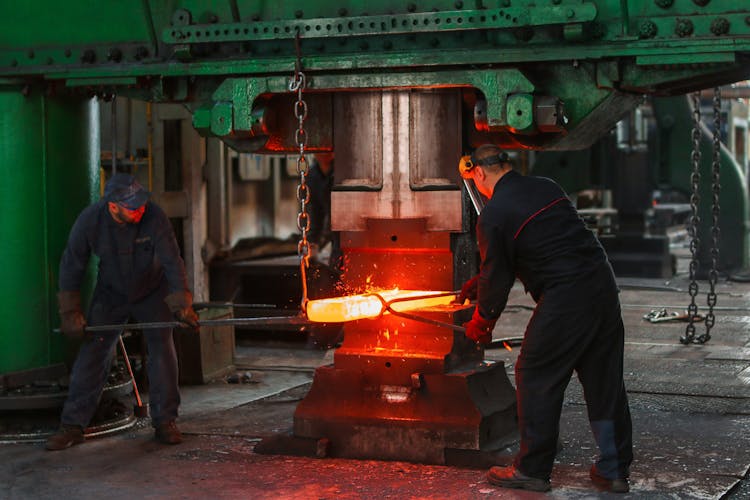 Two Men Holding Two Gray Metal Tools